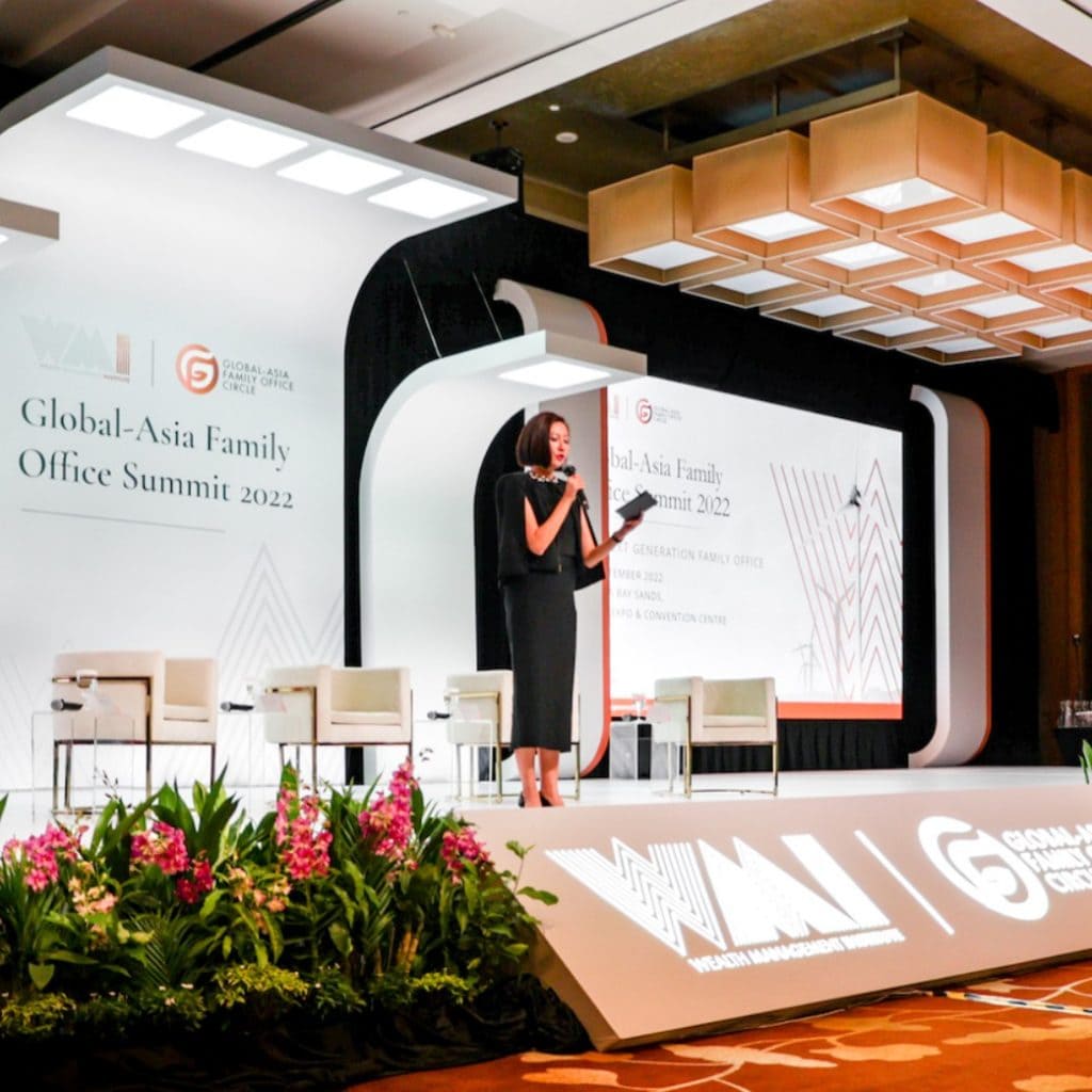 Female speaker presenting on stage at the Global-Asia Family Office Summit 2022