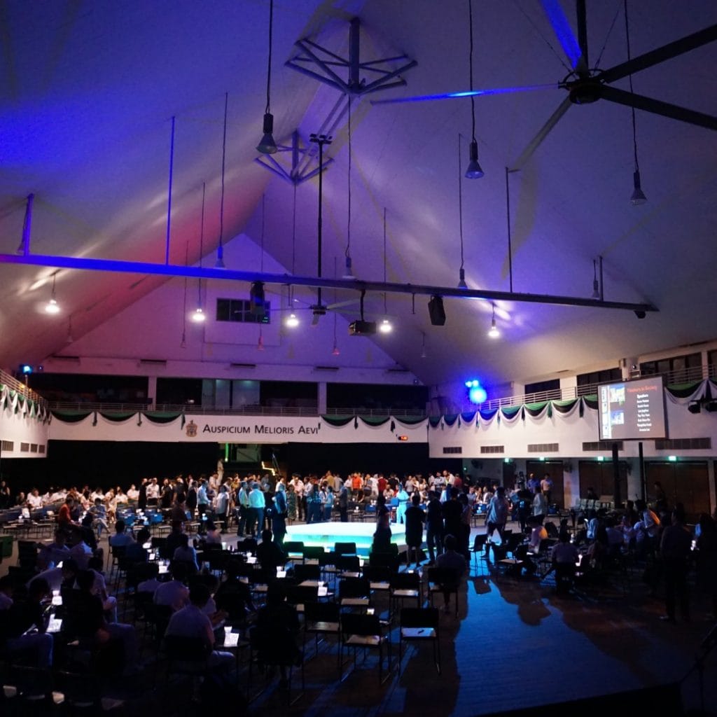Wide shot of a large event hall during an event managed under the banner 'Auspiciu Melioris Aevi'.