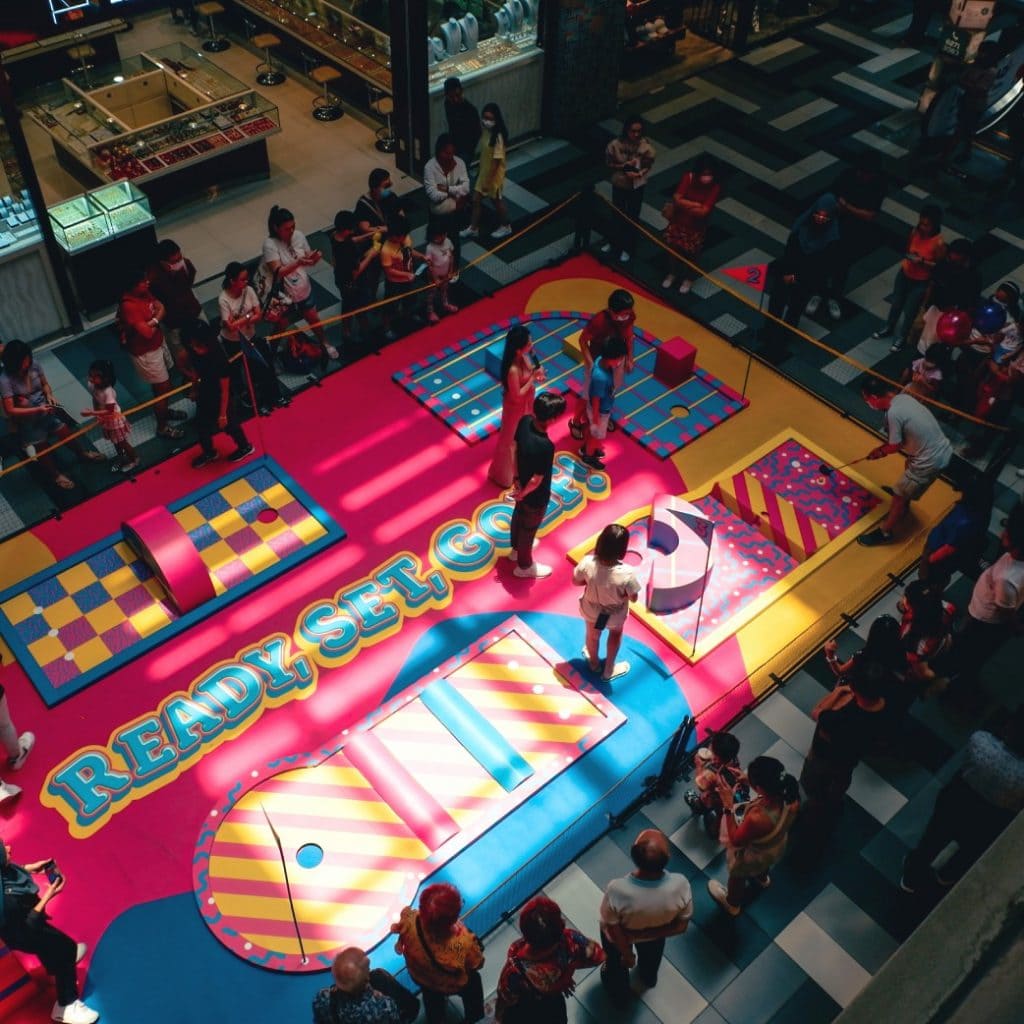 mini-golf experiential events activation set up in a shopping mall, with families participating