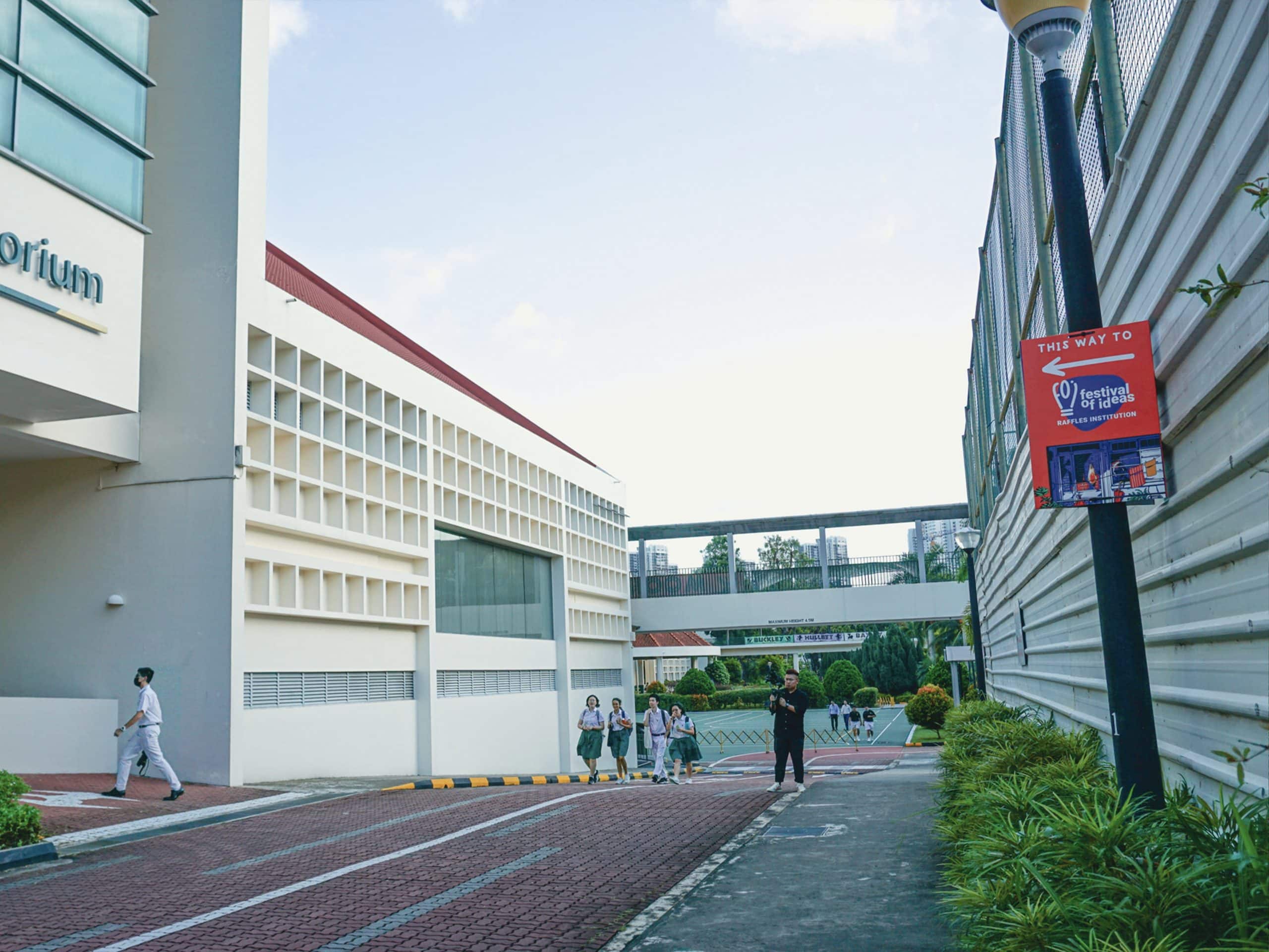 Outdoor view at Raffles Institution during the Festival of Ideas, showing event management in action with signage