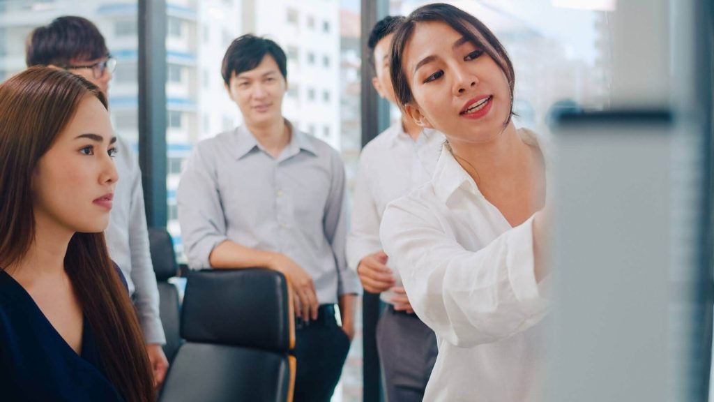 An event organizer company team leader presenting and briefing her colleagues during an event planning meeting